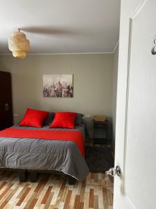 a bedroom with a bed with red pillows at Hostal el valle in Angol