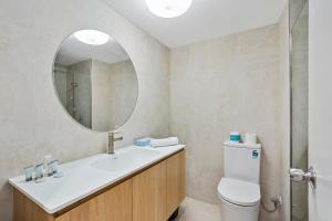 ein Badezimmer mit Waschbecken und Spiegel in der Unterkunft The Oceanfront in Cairns