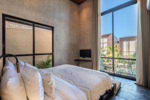 a bedroom with a bed and a large window at The Sirocco Villas Bingin by Sandara in Bingin Beach