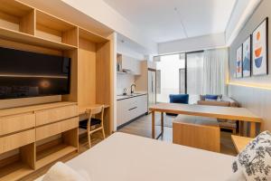 a hotel room with a bed and a tv at Myla Magnolia in Mexico City