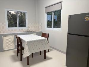eine Küche mit einem Tisch und einem Kühlschrank in der Unterkunft Mini House in Koh Samui 