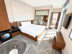 a hotel room with a bed and a television at HT Hotel Hà Tĩnh in Hà Tĩnh
