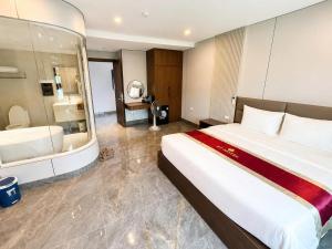 a hotel room with a large bed and a bathroom at HT Hotel Hà Tĩnh in Hà Tĩnh