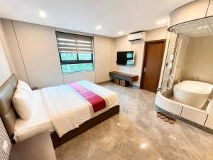 a bedroom with a large bed and a tub at HT Hotel Hà Tĩnh in Hà Tĩnh +25 photos