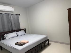 ein Schlafzimmer mit einem Bett mit weißer Bettwäsche und einem Fenster in der Unterkunft Mini House in Koh Samui 
