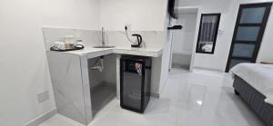 a white bathroom with a sink and a counter in a room at SADO Guesthouse in Katima Mulilo