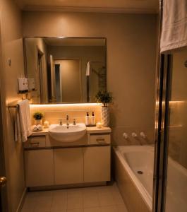 a bathroom with a sink and a tub and a mirror at ClickClock Hotel in Melbourne +42 photos