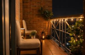 a balcony with two chairs and a railing with lights at ClickClock Hotel in Melbourne