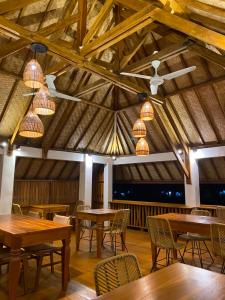 a dining room with wooden tables and chairs at Tetebatu Sunset House in Tetebatu