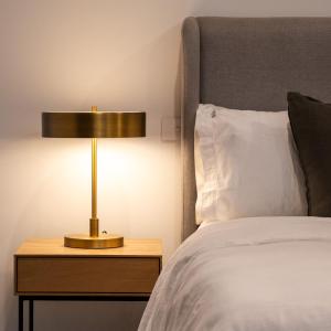 a lamp on a night stand next to a bed at The Sett in Sassafras
