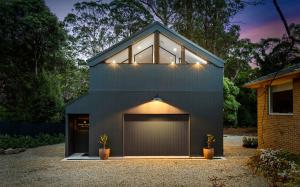 a house with a garage with lights on it at The Sett in Sassafras