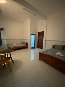 a room with two beds and a table in it at Nhà Nghỉ 36 in Ga Trảng Bôm