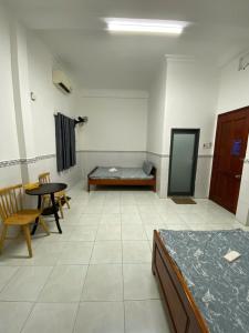 a room with a bed and a table and chairs at Nhà Nghỉ 36 in Ga Trảng Bôm