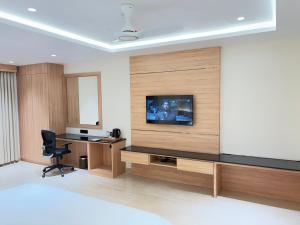 a room with a tv on a wall with a desk at M Convention Eluru in Elūru