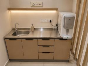 a kitchen with a sink and a microwave at Citto Inn Bangi in Bandar Baru Bangi +4 photos
