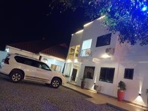 a white van parked in front of a white house at night at Excel Roses Hotels in Kontrajeso +1 photo