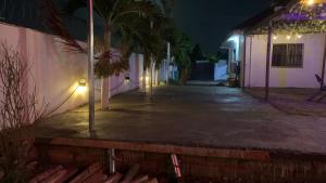 an empty street at night with palm trees and lights at Excel Roses Hotels in Kontrajeso