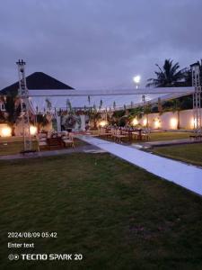 a walkway leading to a resort with tables and chairs at Excel Roses Hotels in Kontrajeso