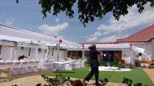 a man taking a picture of a marquee with white tables and chairs at Excel Roses Hotels in Kontrajeso