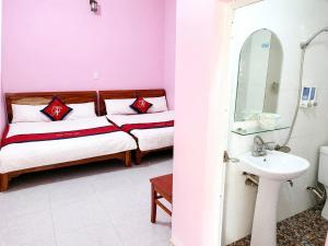 a bedroom with two beds and a sink and a mirror at Thiên Phúc Hotel in Mộc Châu +17 photos