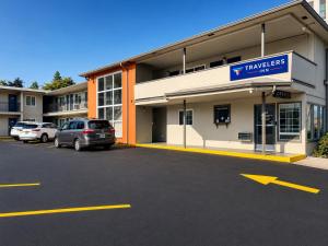 a car parked in a parking lot in front of a hotel at Travelers Inn Eugene University in Eugene
