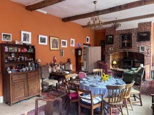 a dining room with a table and chairs and a fireplace at Walsingham Bakehouse in Little Walsingham