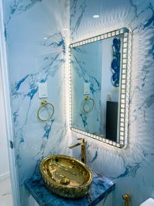a bathroom with a gold sink and a mirror at City View at The Gramercy Residences in Makati
