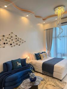 a bedroom with two beds and a chandelier at City View at The Gramercy Residences in Makati