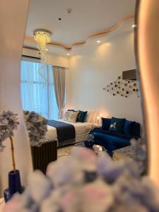 a bedroom with a bed and a blue couch at City View at The Gramercy Residences in Makati