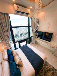 a bedroom with a large bed and a tv at City View at The Gramercy Residences in Makati