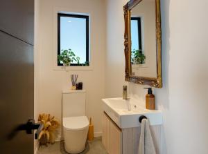 a bathroom with a sink and a mirror and a toilet at The Highland - Sunset Ridge in Ruatapu +35 photos