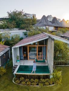 a woman is standing in the middle of a tiny house at Shore Amora Canggu in Canggu