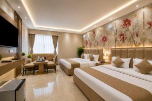 a hotel room with two beds and a television at Hotel Kelvish Plaza-Delhi Airport in New Delhi