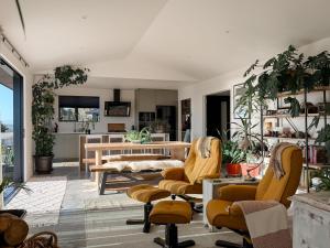 a living room with yellow chairs and a table at The Highland - Sunset Ridge in Ruatapu