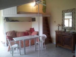 サン・ジロンにあるL'Ananda Studioのテーブルと椅子、二段ベッドが備わる客室です。