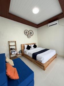 ein Schlafzimmer mit einem Bett und einem blauen Sofa in der Unterkunft Pinggan Infinity - Private Pool Villa in Kintamani in Gretek
