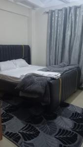 a bedroom with a bed with a black frame and a rug at Cess cozy stay maua in Maua