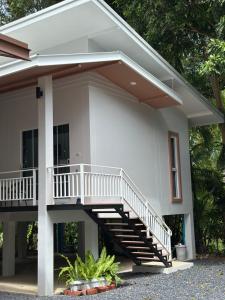 a house with a staircase in front of it at The Summer Cozy Cottage 2 in Haad Chao Phao