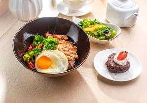 a bowl of food with an egg and broccoli on a table at Khangain Tugul Hotel in Tsetserleg