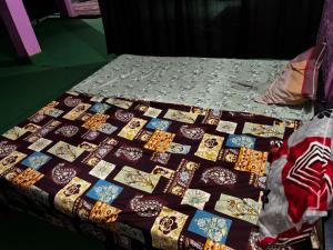 a bed with a quilt on top of it at Brijwasi Seva Sadan in Mathura