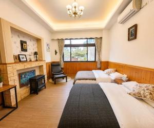 a bedroom with two beds and a fireplace at 日月潭 讀好聚民宿 2-22人 一次只接待一組 in Yuchi