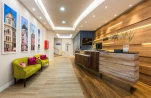 a lobby with a reception desk and two green chairs at Hotel Madrid Centro, Affiliated by Meliá in Madrid