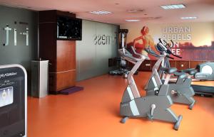 a gym with a treadmill and a woman on a poster at Hotel Madrid Centro, Affiliated by Meliá in Madrid