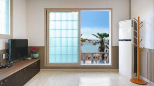 a room with a window with a view of the ocean at Geoje Youngsu Pension in Geoje +9 photos