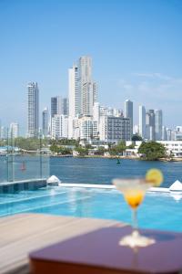a drink sitting on a table with a view of a city at GHL Arsenal Hotel in Cartagena de Indias