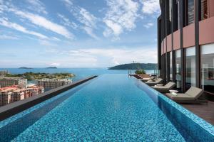 an infinity pool on a building with a view of the water at Sheraton Kota Kinabalu in Kota Kinabalu