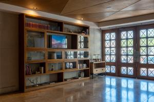 a living room with wooden shelves and a television at GHL Arsenal Hotel in Cartagena de Indias