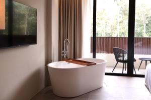 a white bath tub in a room with a bedroom at By The Hill in Bukit Mertajam