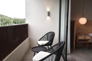 two chairs sitting on the balcony of a room at By The Hill in Bukit Mertajam