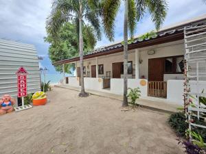 a building with palm trees in front of it at Ao Klang Beach Resort in Ko Samed